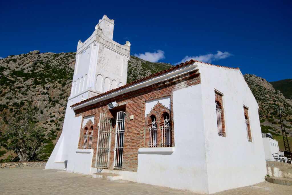 Solo travel Chefchaouen: The whitewashed Spanish Mosque backed by the Rif Mountains
