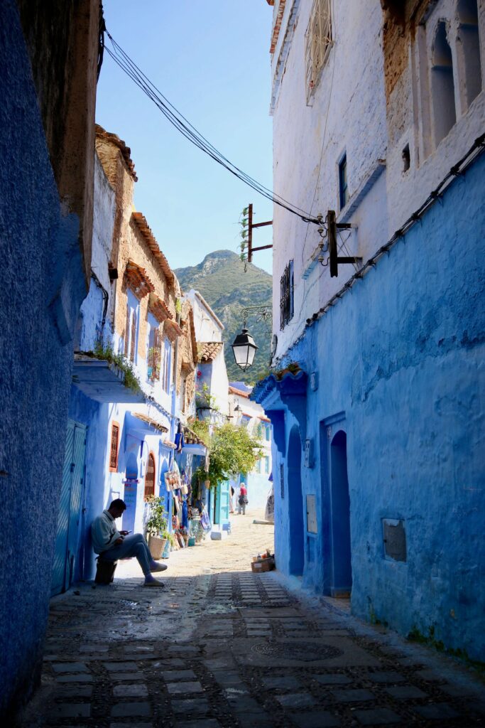 Blue and white houses line a street in the Chefchaouen medina