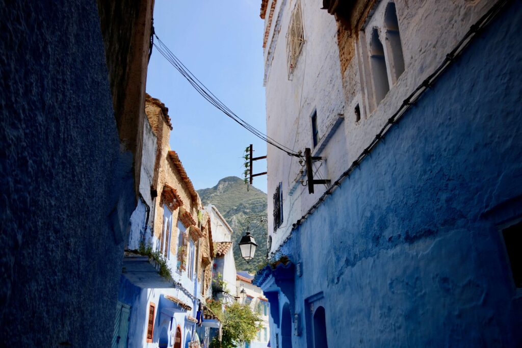 Blue-hued buildings line a narrow street in Chefchaouen - top travel experiences in Morocco