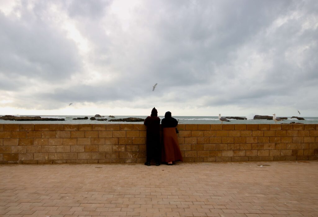 A Moroccan couple look toward the Atlantic Ocean at the Essaouira port