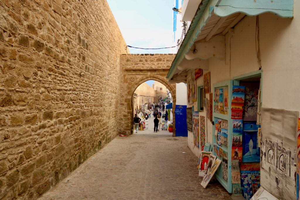 Best things to do in Essaouira: Paintings outside a gallery beside the stone walls of Skala de la Kasbah