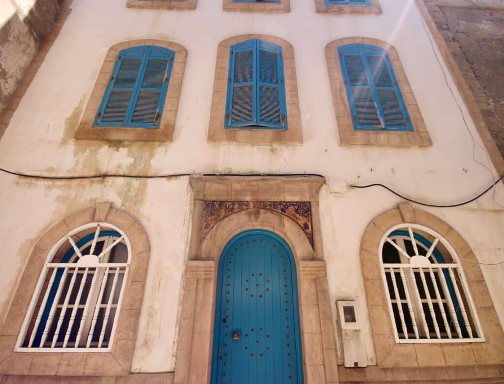 Blue-shuttered windows on a whitewashed building in Essaouira