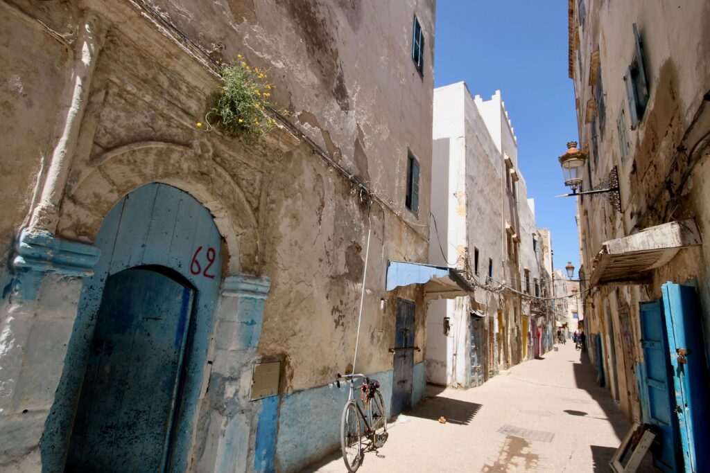 Blue and white buildings line a narrow street in the Essaouira medina - a popular destination for solo travellers in Morocco