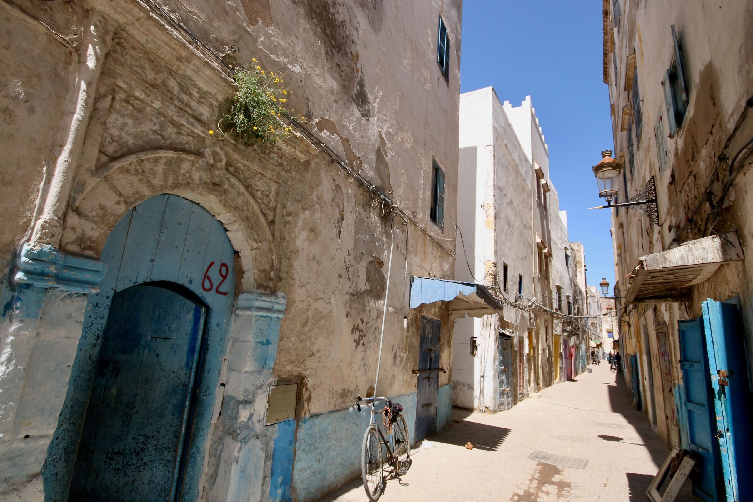 Blue and white buildings line a narrow street in the Essaouira medina