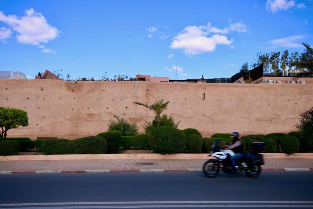 A motorbike whizzes by the medina walls of Marrakech