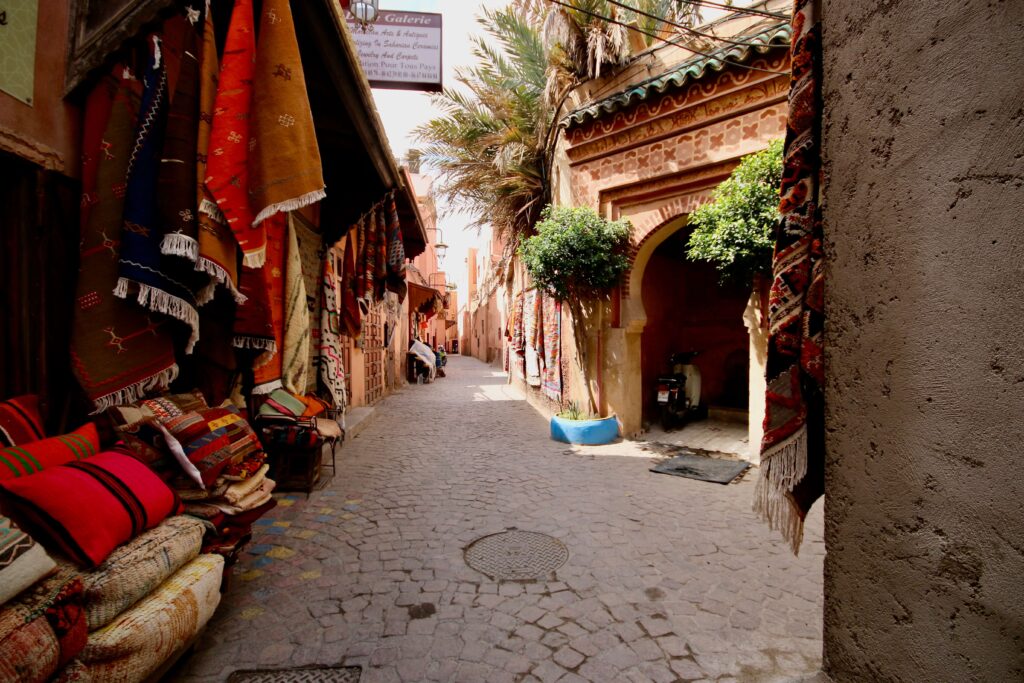 Colourful rugs for sale in a narrow street of the Marrakech medina