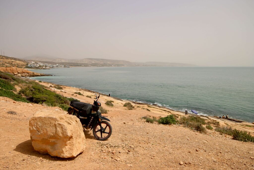 A motorbike parked on the Atlantic coast, which can be explored independently when driving in Morocco as a solo traveller