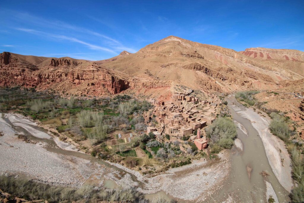 An ochre-coloured village on a river bend in the Valley of the Roses - a destination that's best explored on a solo road trip in Morocco