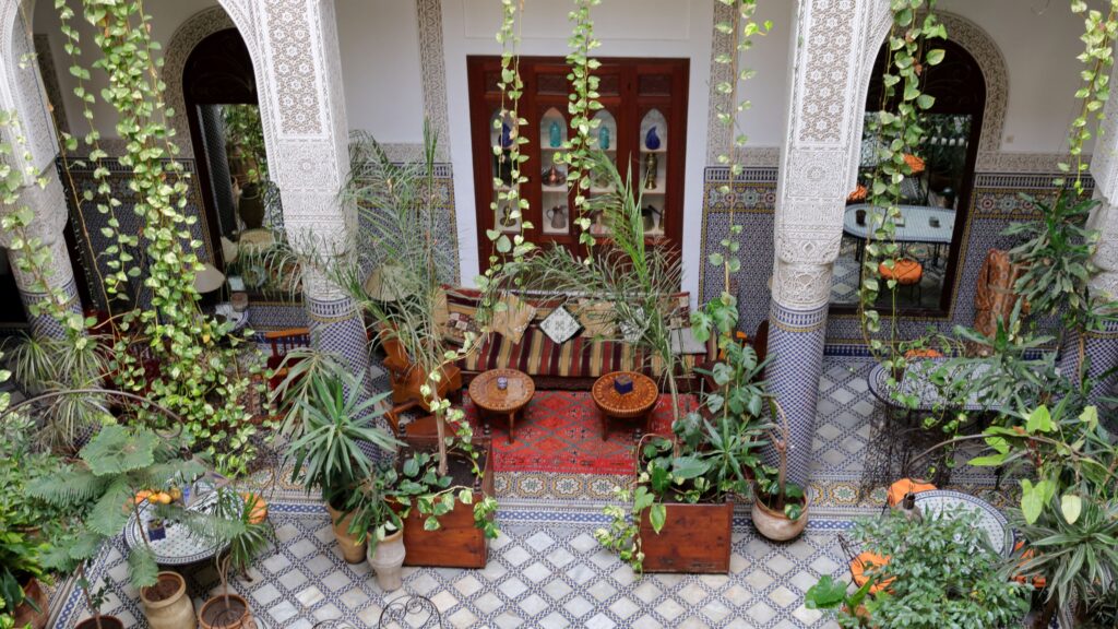 Hanging plants decorate the interior courtyard of Riad Al Bartal in Fes