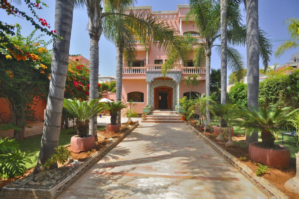 A tree-lined trail leads to the entrance of a highly-rated Casablanca hostel