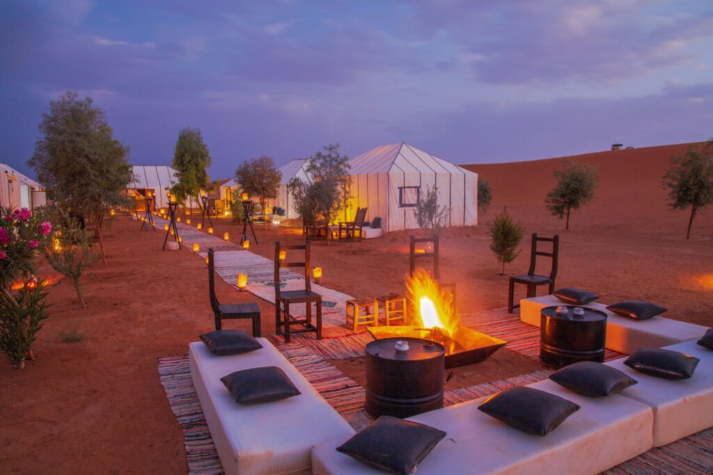 Luxury tents surround a campfire at Erg Chebbi Camp near Merzouga
