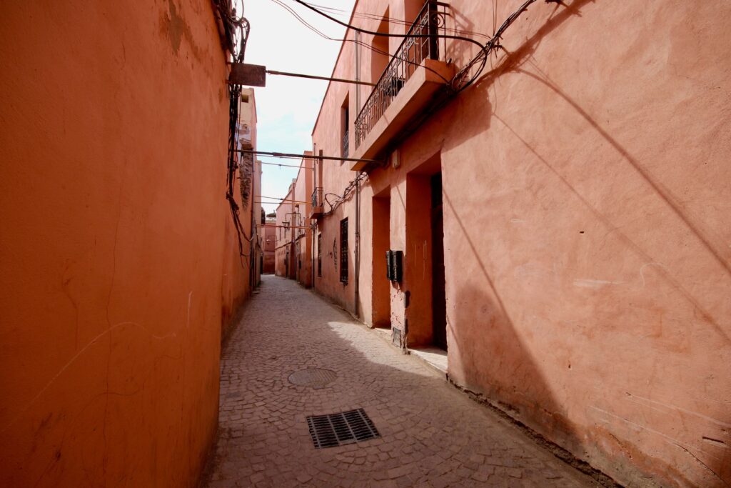 Ochre buildings line a narrow street in the Marrakech medina