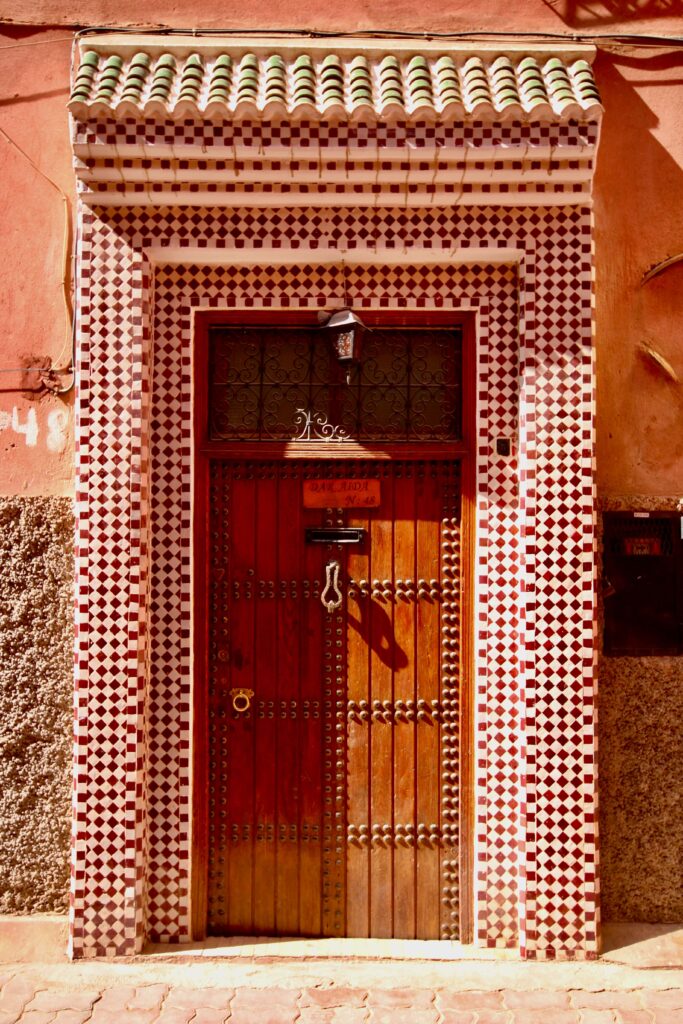 Beautiful tilework frames a wooden doorway in the Marrakech medina