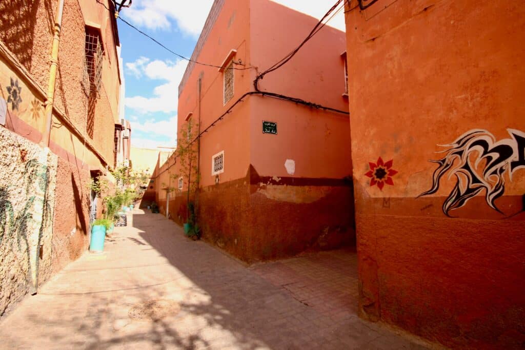 Ochre buildings line a narrow street in the Marrakech medina